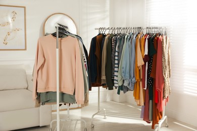 Photo of Racks with stylish clothes indoors. Fast fashion