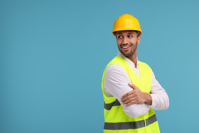 Engineer in hard hat on light blue background, space for text