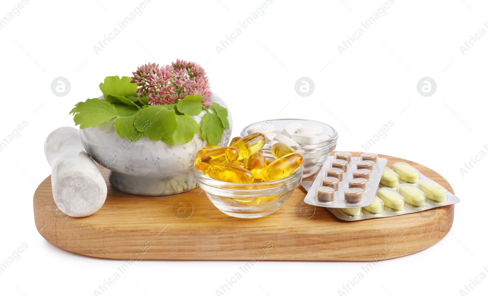 Photo of Board with mortar, fresh herbs and pills on white background