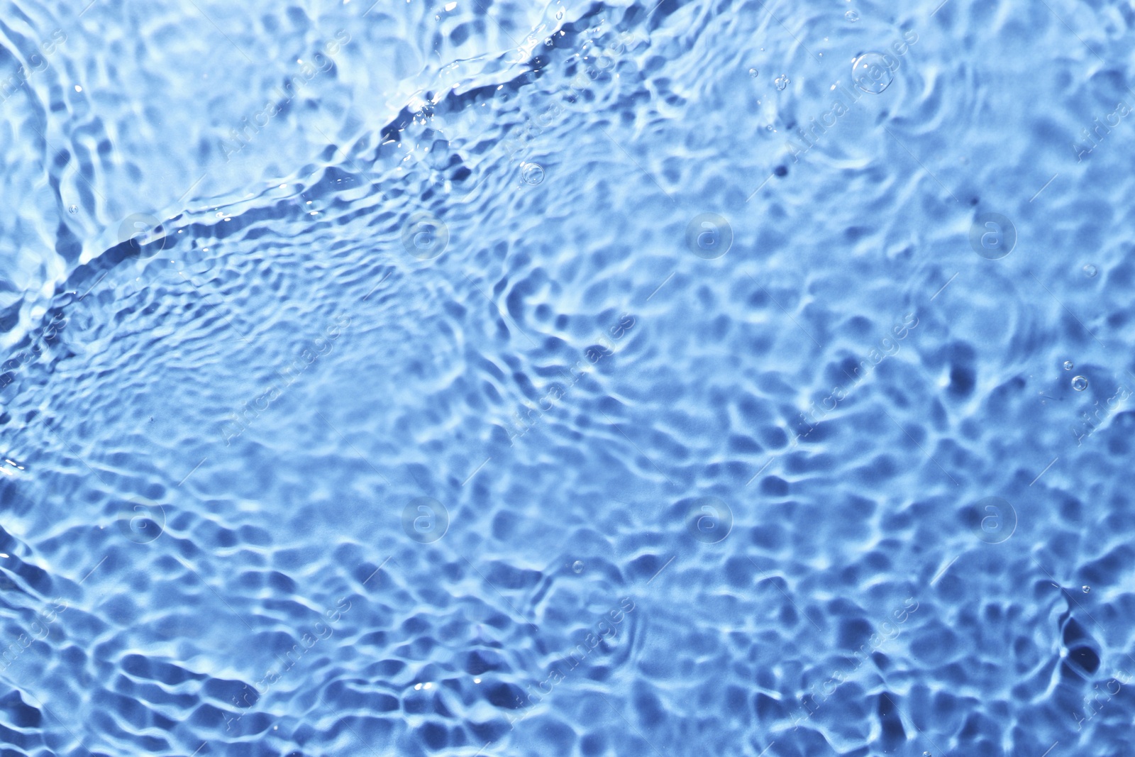 Image of Rippled surface of clear water on light blue background, top view