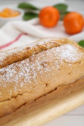 Photo of Delicious homemade yogurt cake with powdered sugar on white wooden table, closeup