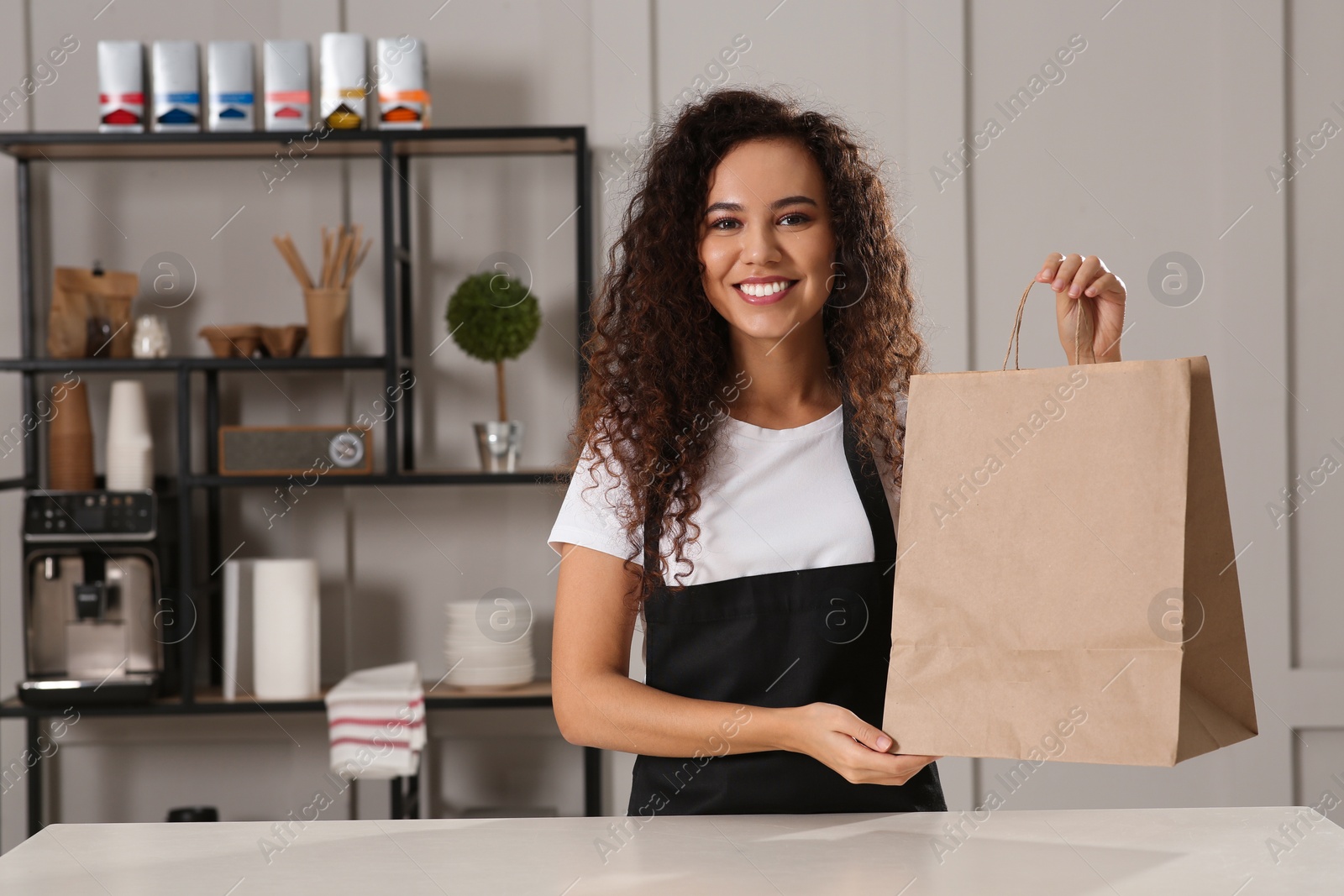 Photo of Worker with paper bag at counter in cafe, space for text