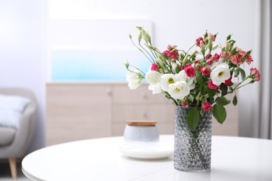 Photo of Vase with beautiful flowers on white table in room, space for text