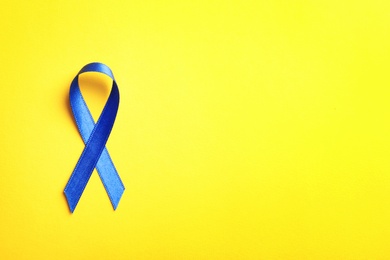 Photo of Blue ribbon on color background, top view. Cancer awareness