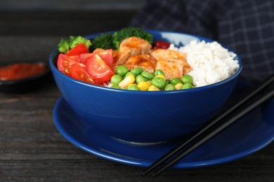 Photo of Bowl of boiled rice with vegetables and meat on table