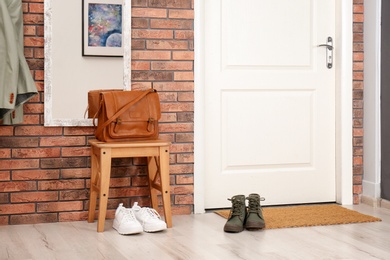 Hallway interior with shoes, mirror and mat near door