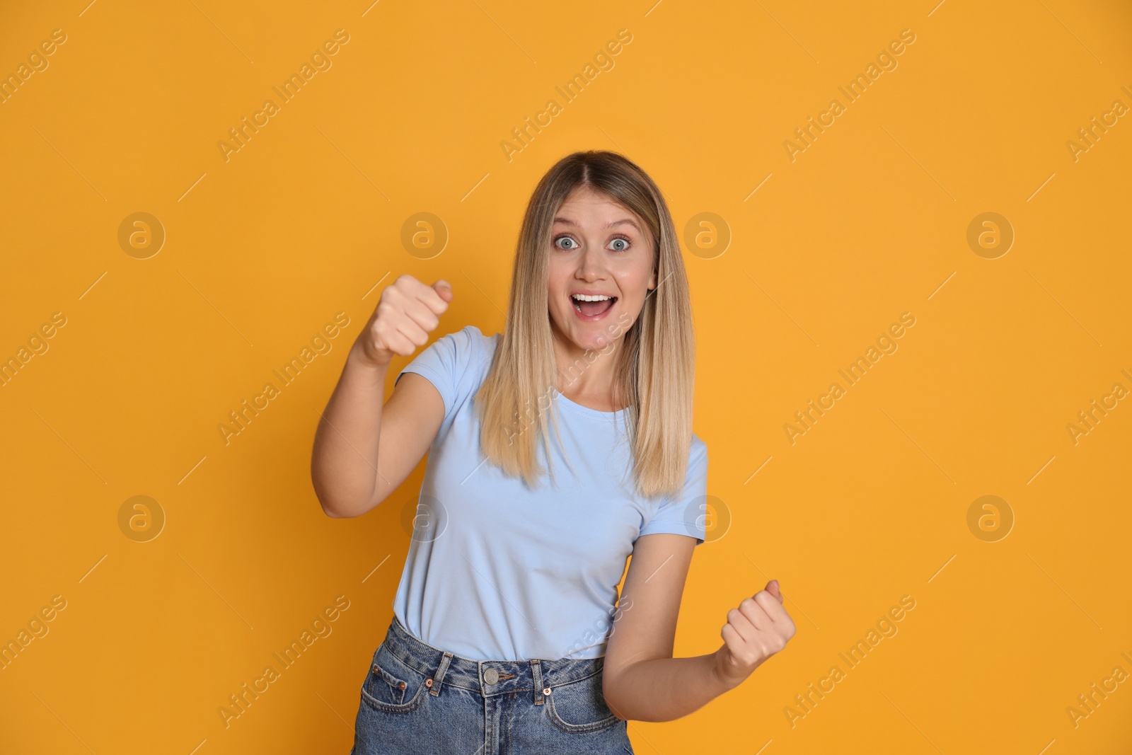 Photo of Emotional young woman pretending to drive car on yellow background