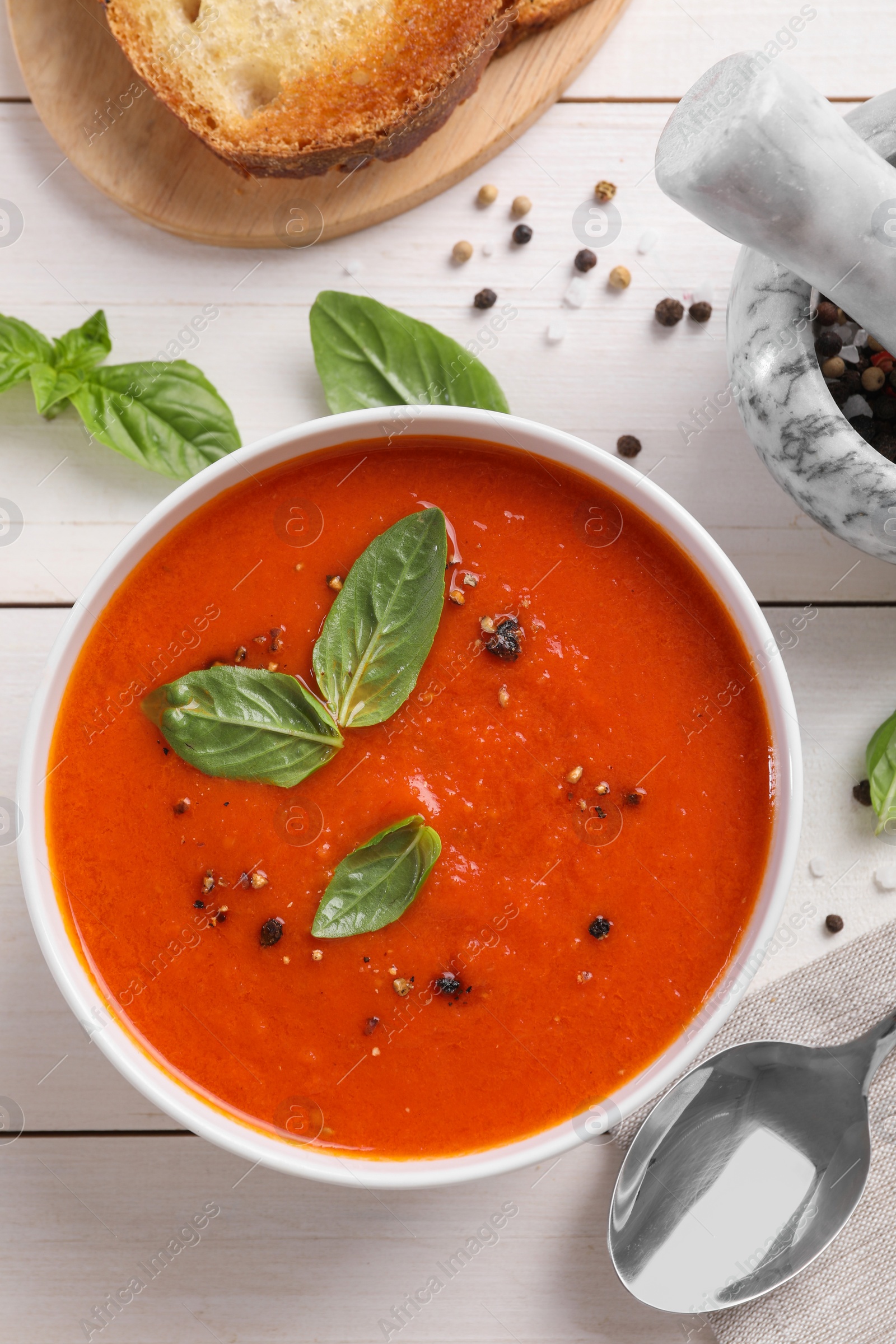 Photo of Flat lay composition with delicious tomato cream soup in bowl on white wooden table