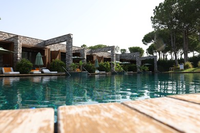 Swimming pool, exotic plants and sunbeds at luxury resort