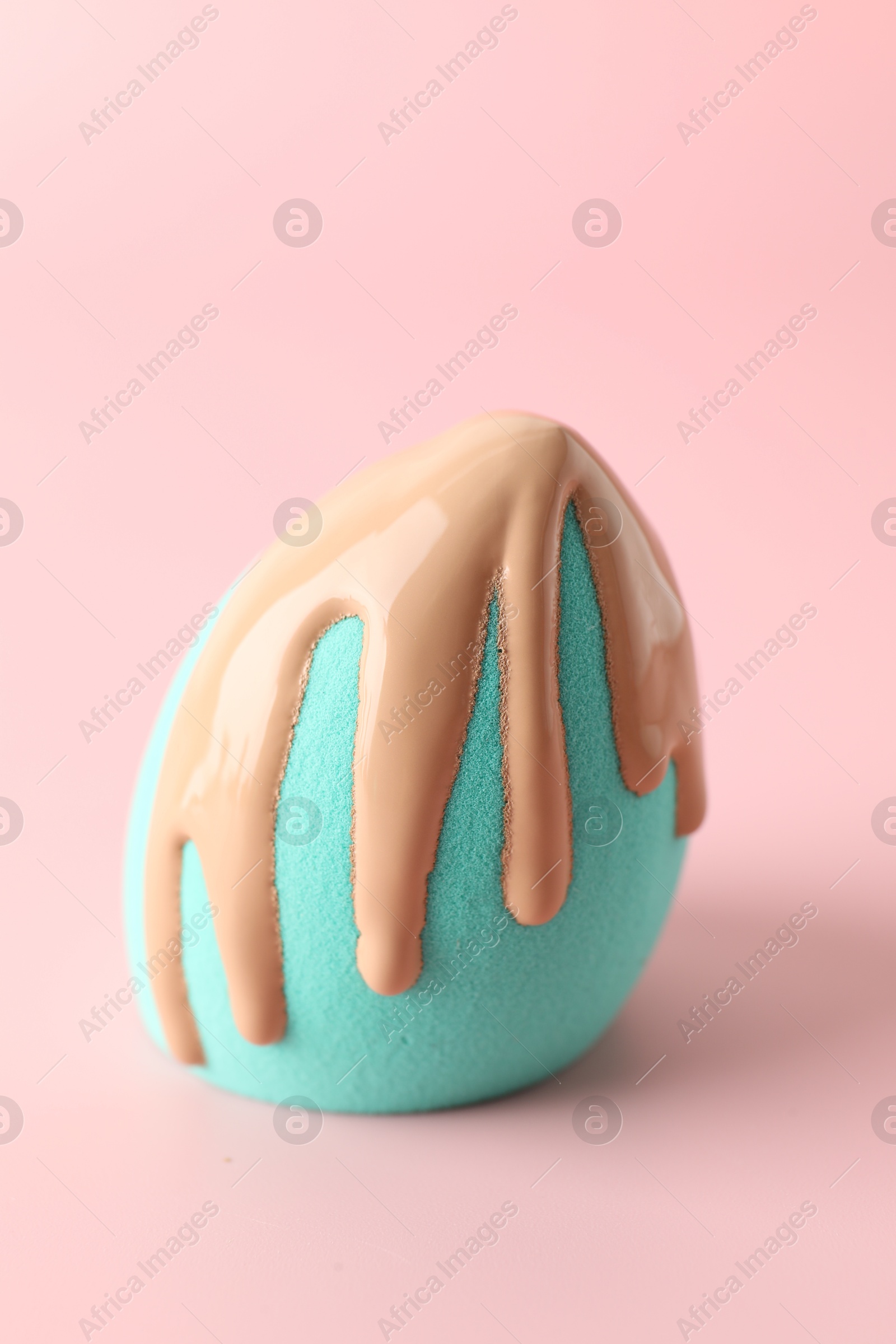 Photo of Makeup sponge with skin foundation on pink background