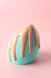 Photo of Makeup sponge with skin foundation on pink background