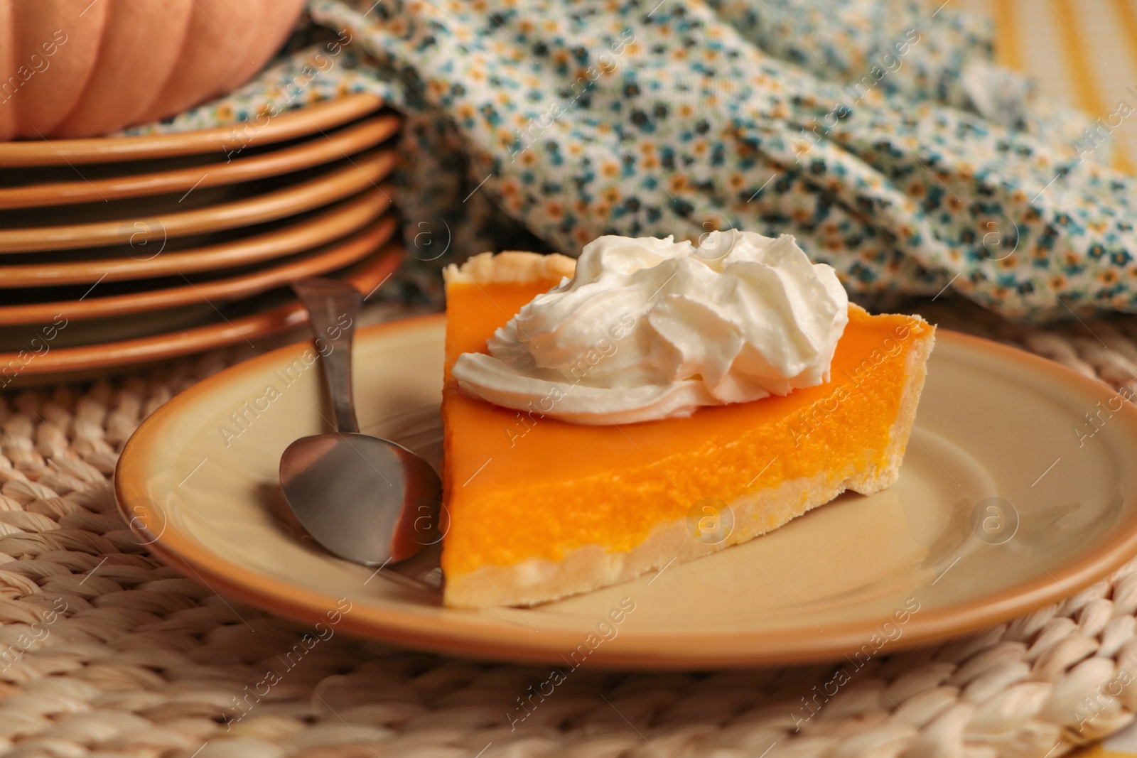 Photo of Piece of fresh homemade pumpkin pie with whipped cream on table