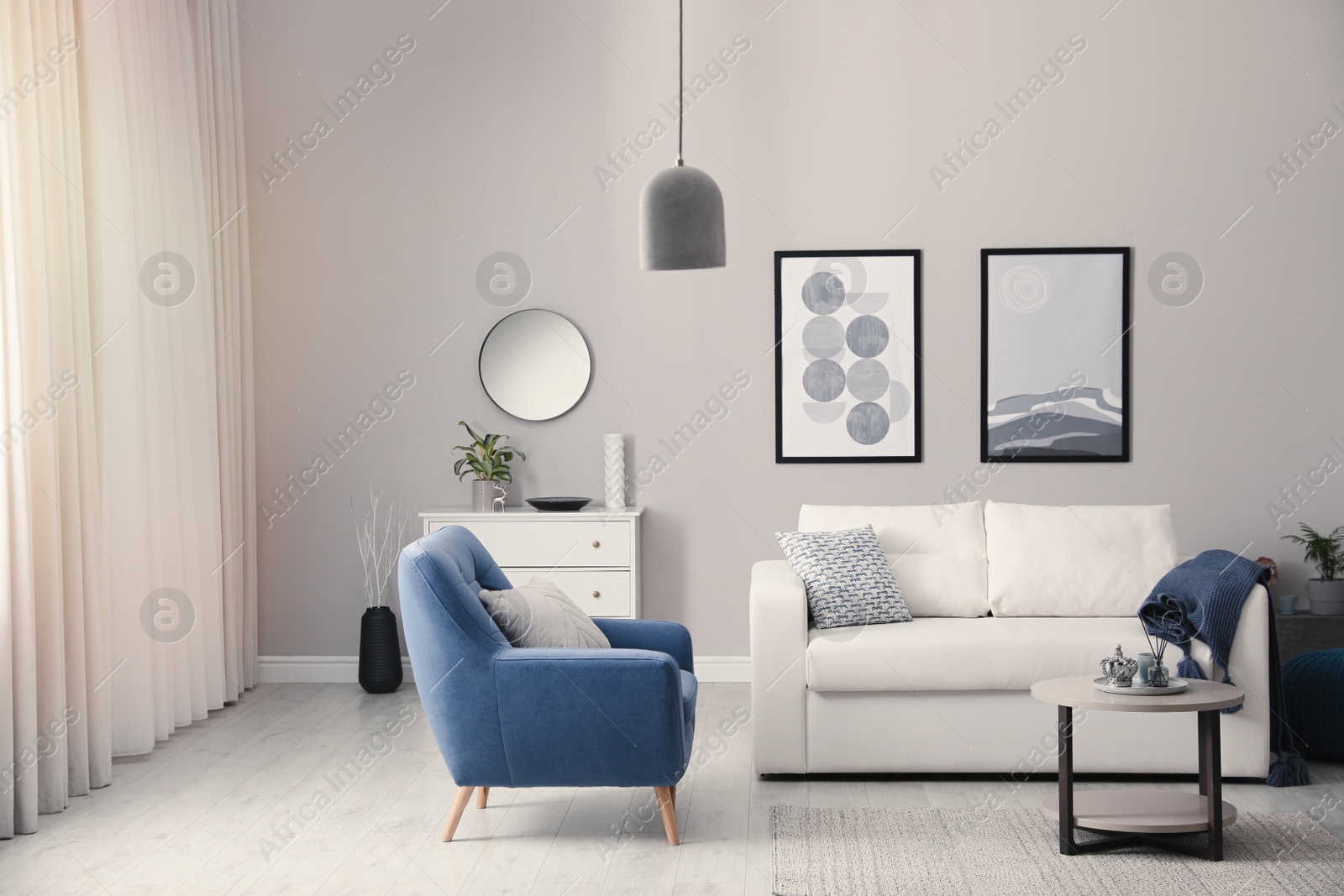 Photo of Stylish living room interior with white sofa, armchair and small coffee table