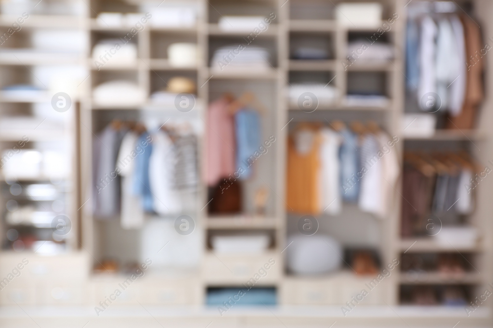 Photo of Blurred view of large wardrobe closet with clothes and home stuff