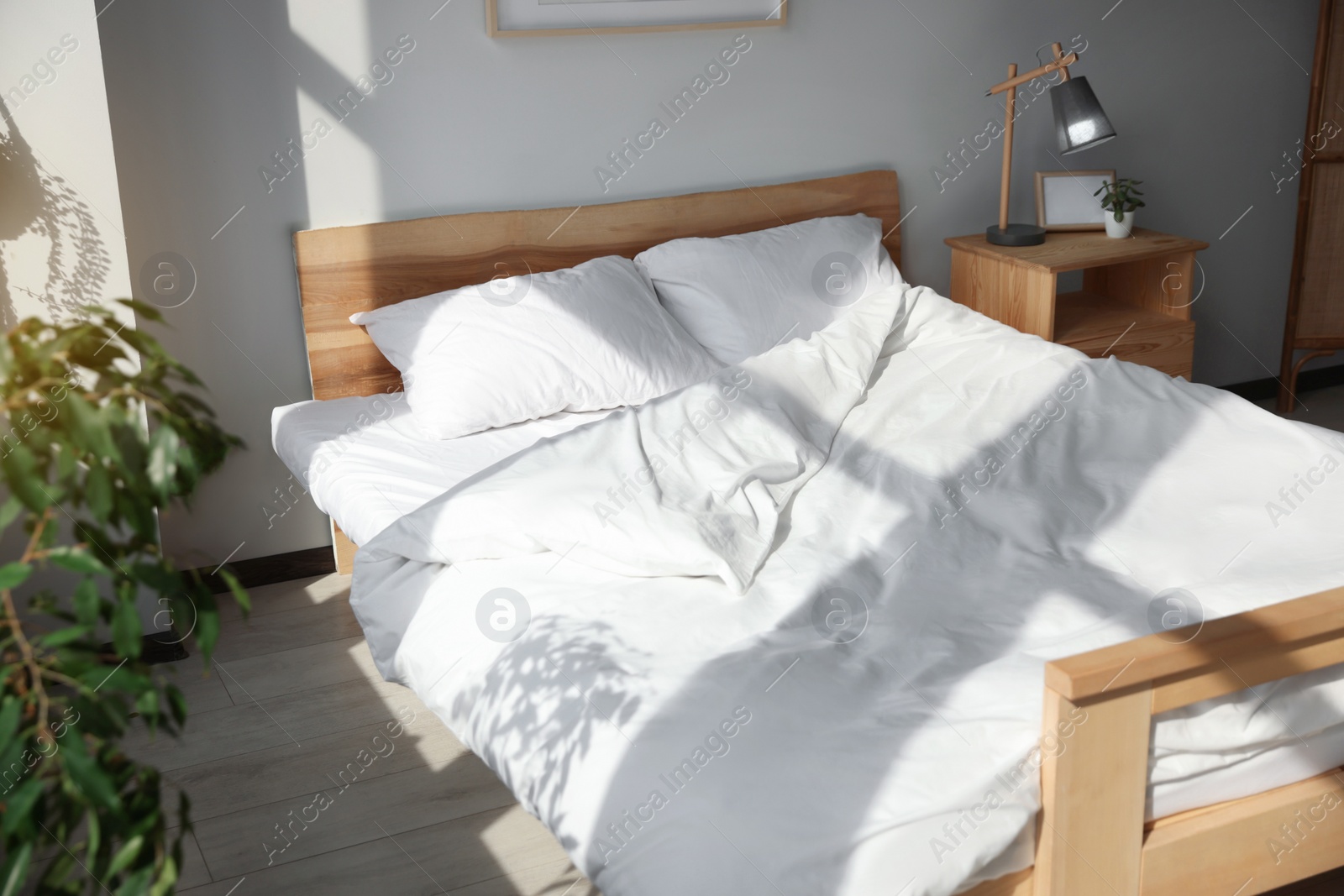 Photo of Large comfortable bed with soft pillows and blanket indoors