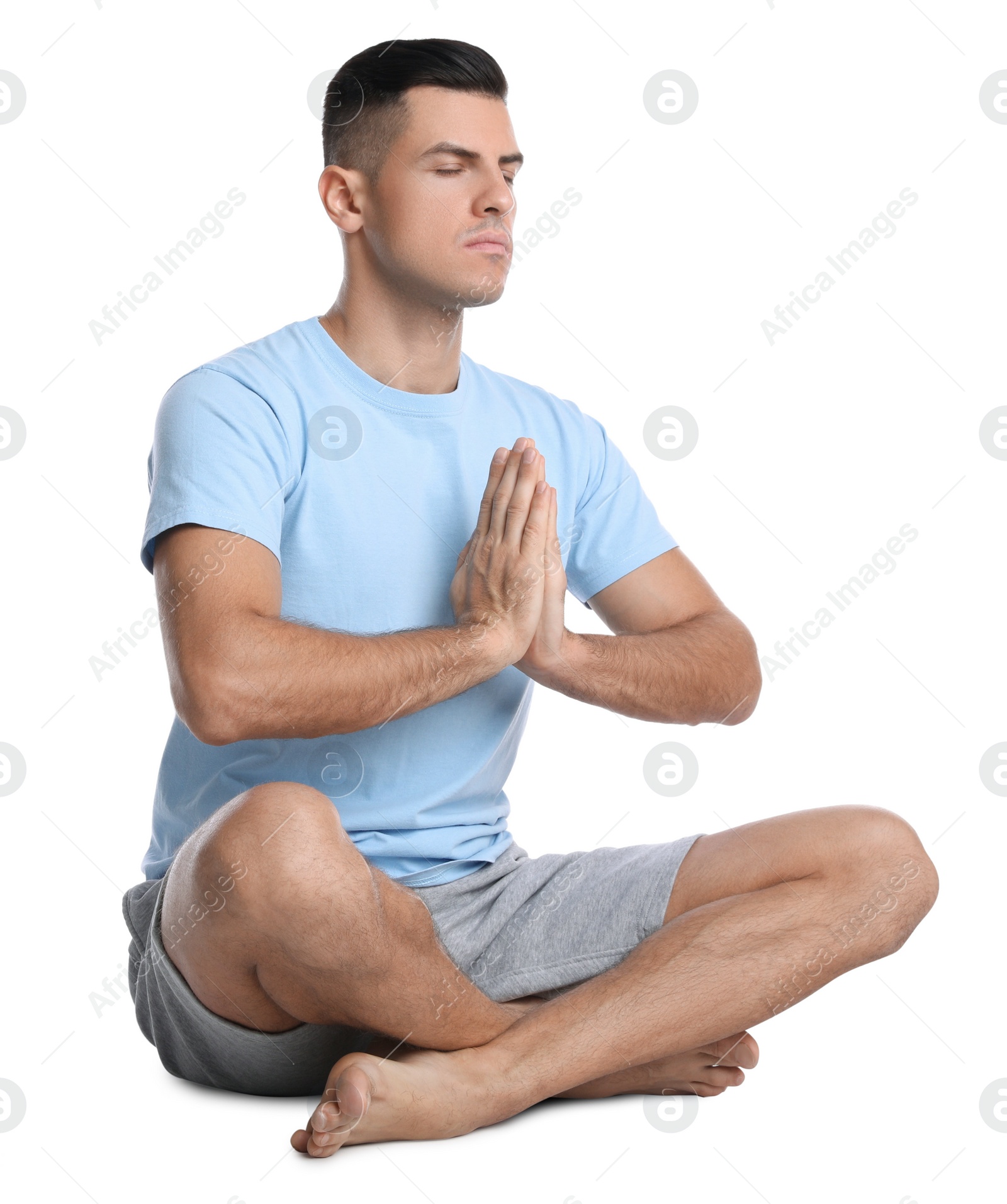 Photo of Handsome man meditating on white background. Harmony and zen