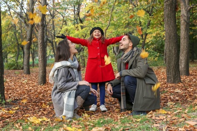 Happy family with child spending time together in park. Autumn walk