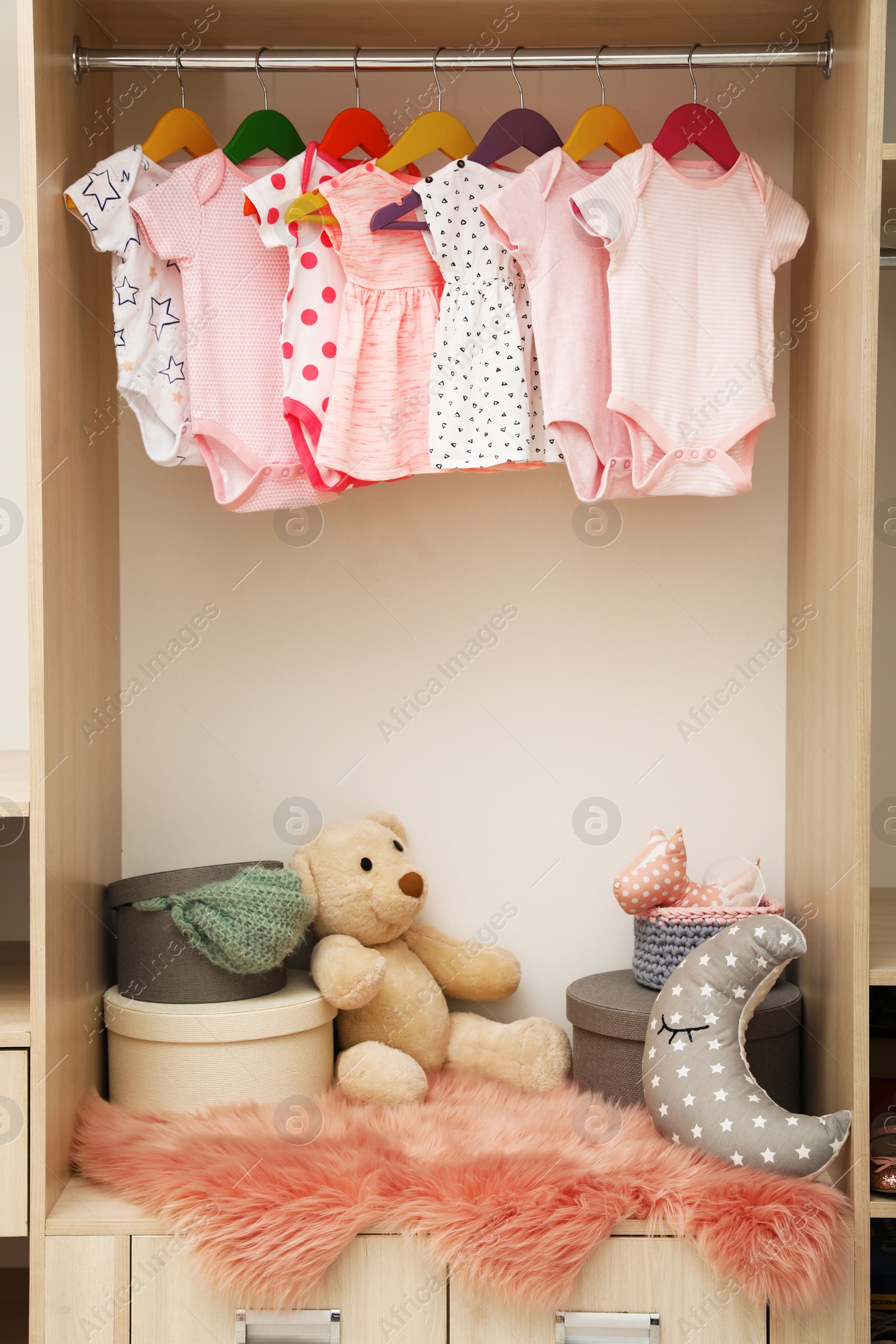 Photo of Wardrobe with cute baby clothes and toys