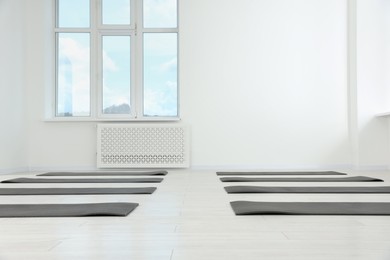 Photo of Spacious yoga studio with exercise mats and big window. Space for text