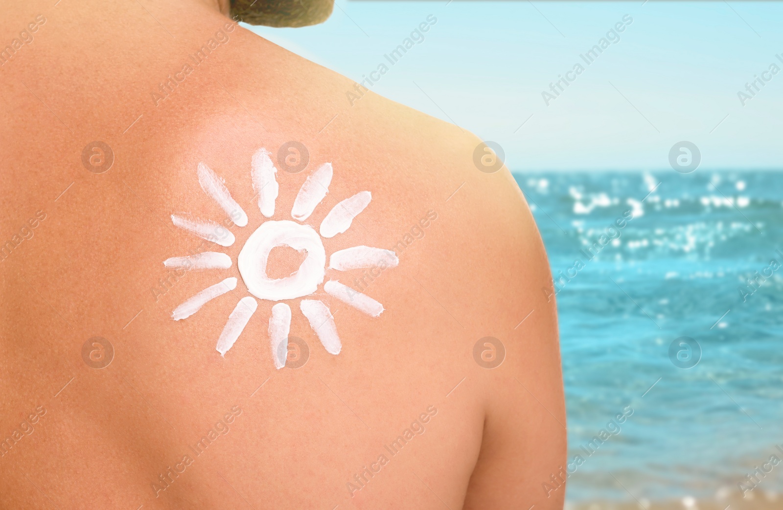 Image of Sun protection. Man with sunblock on his back near sea, closeup