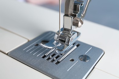 Photo of White sewing machine on light background, closeup