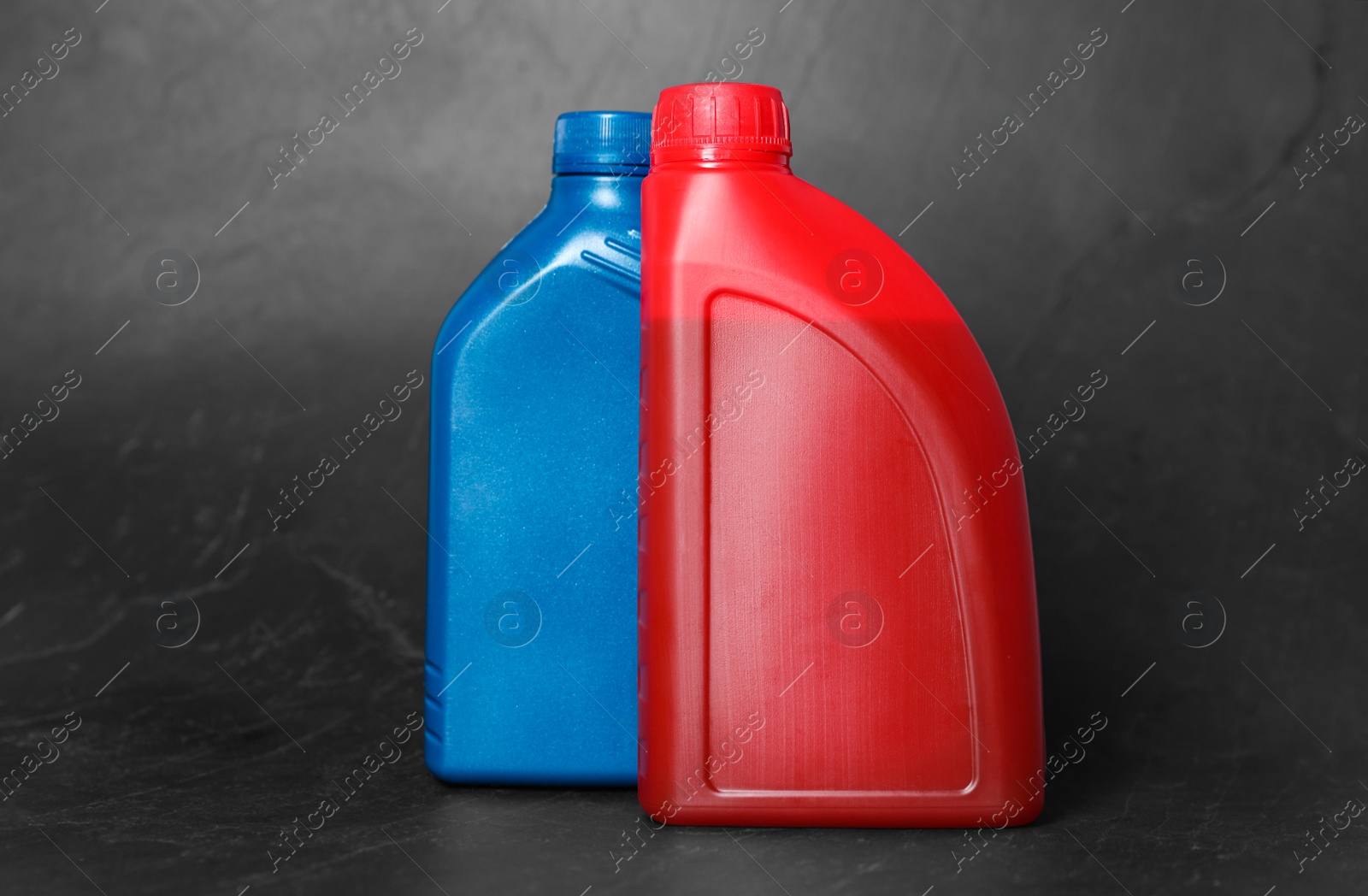 Photo of Motor oil in different canisters on black background