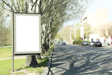 Photo of Blank advertising board near road outdoors. Space for design