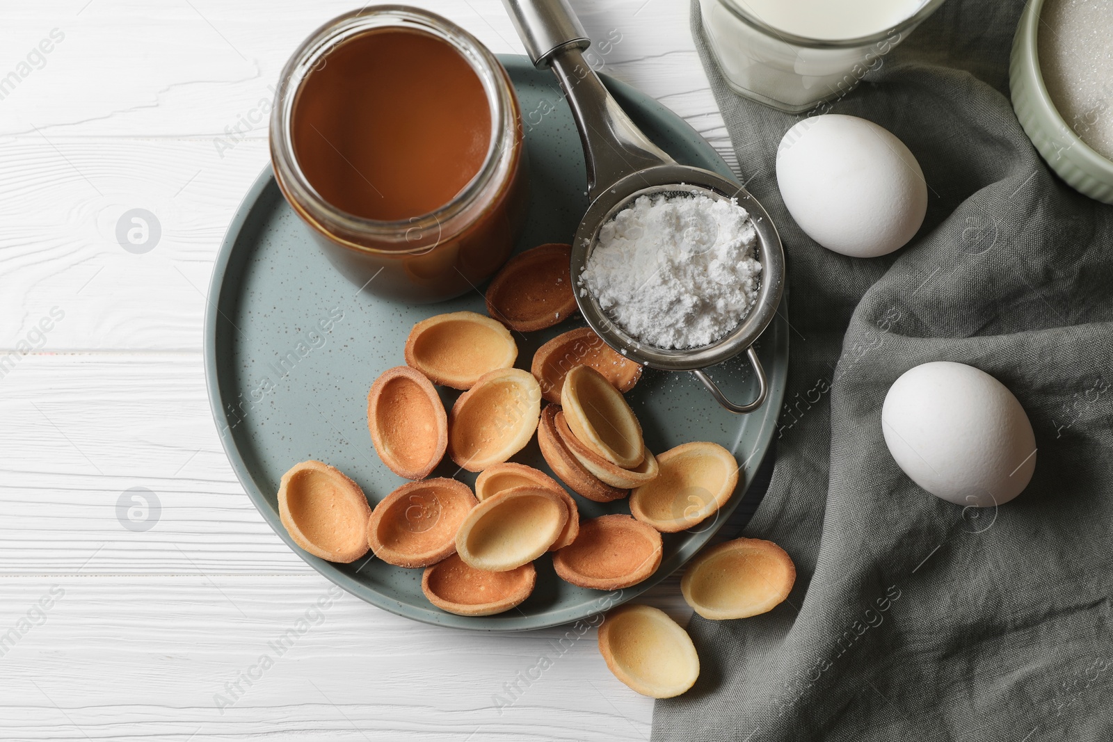 Photo of Ingredients for delicious walnut shaped cookies with condensed milk on white wooden table, flat lay