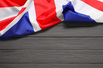 Photo of Flag of United Kingdom on gray wooden background, top view. Space for text