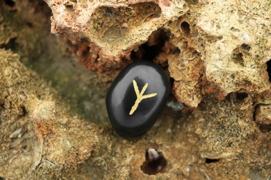 Black rune Algiz on stone outdoors, closeup