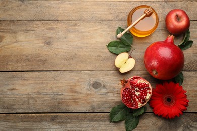 Flat lay composition with Rosh Hashanah holiday attributes on wooden table. Space for text