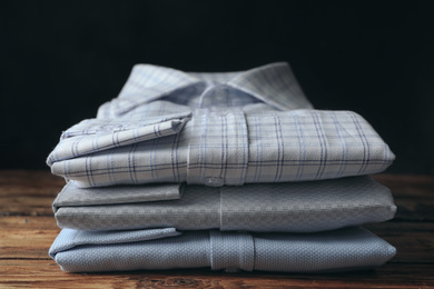 Photo of Stack of classic shirts on wooden table