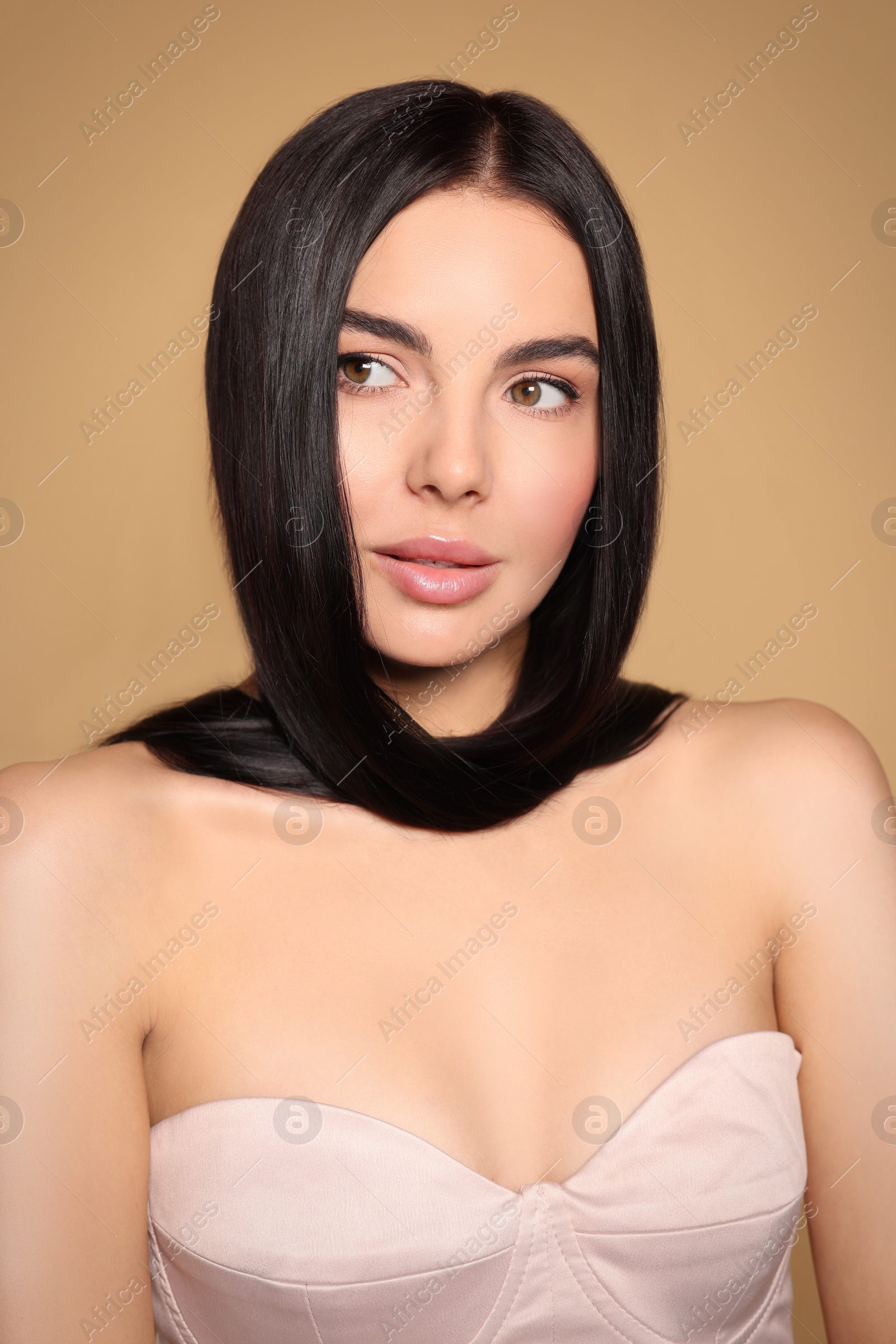 Photo of Portrait of beautiful young woman with healthy strong hair on beige background