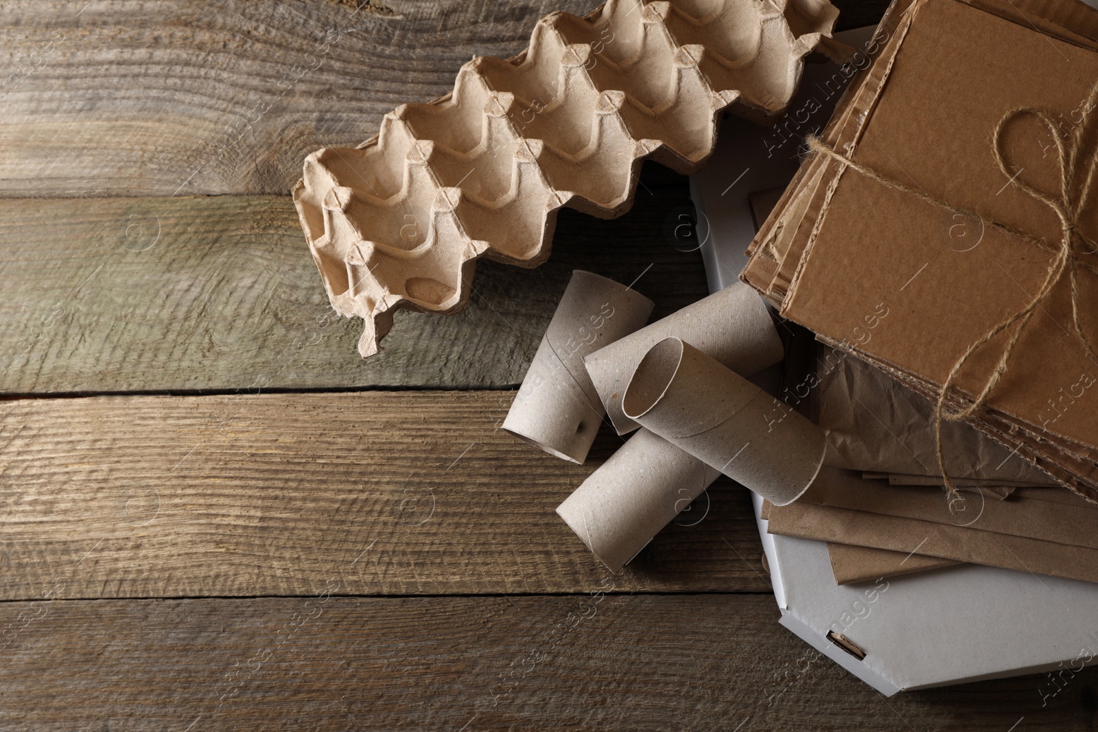 Photo of Different waste paper on wooden table, flat lay. Space for text