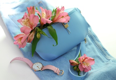 Photo of Composition with stylish bump bag and spring flowers on light background