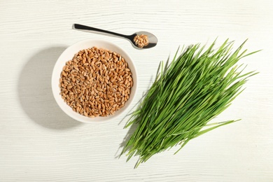 Flat lay composition with wheat grass and seeds on white wooden background