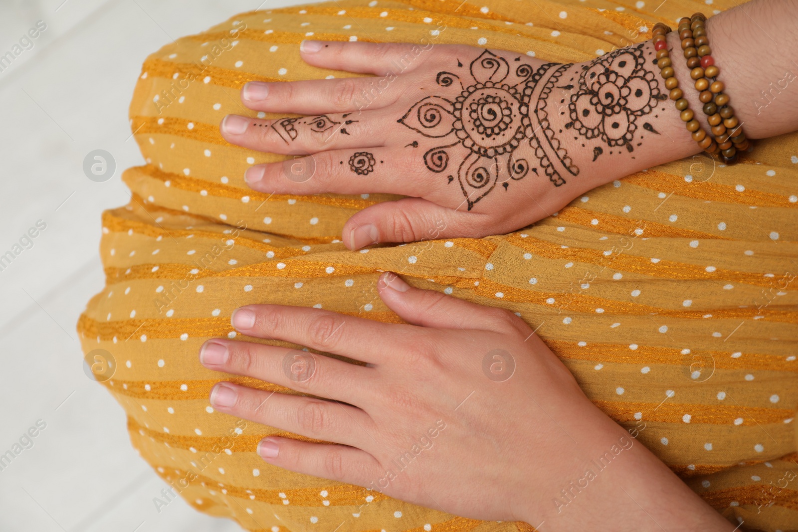 Photo of Woman with beautiful henna tattoo on hand, top view. Traditional mehndi