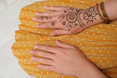 Photo of Woman with beautiful henna tattoo on hand, top view. Traditional mehndi