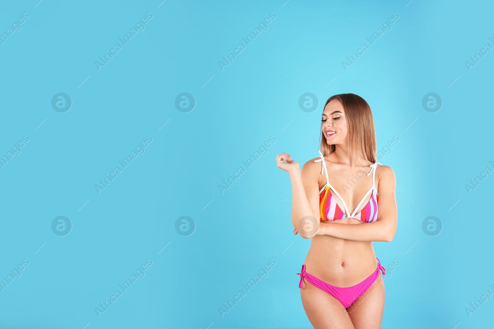 Photo of Pretty sexy woman with slim body in stylish bikini on color background, space for text