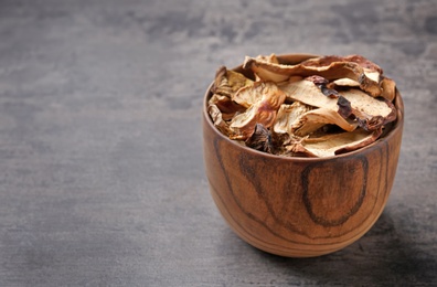 Photo of Bowl of dried mushrooms on color background. Space for text