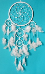 Beautiful dream catcher hanging on light blue background