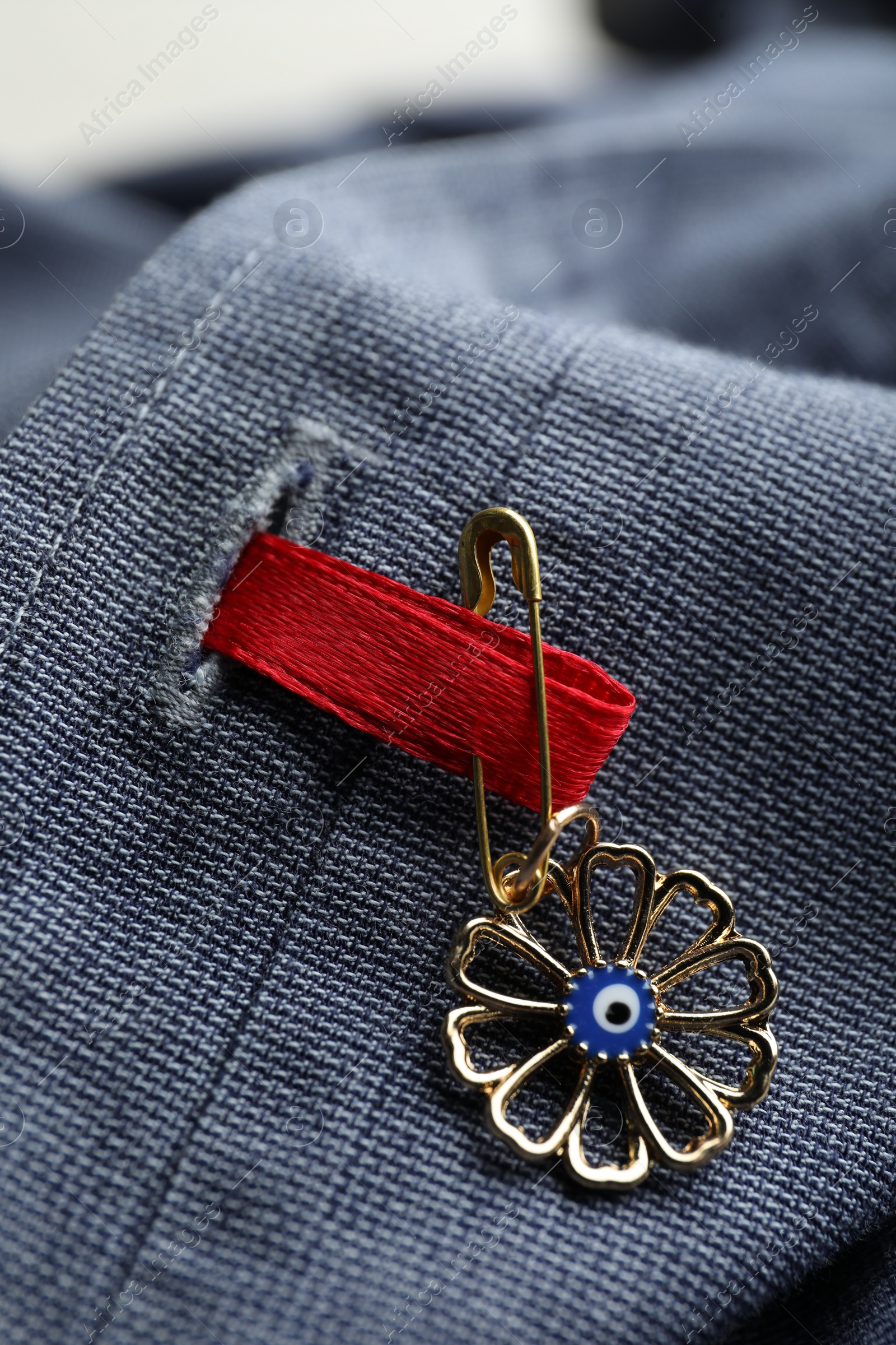 Photo of Evil eye safety pin on clothing, closeup