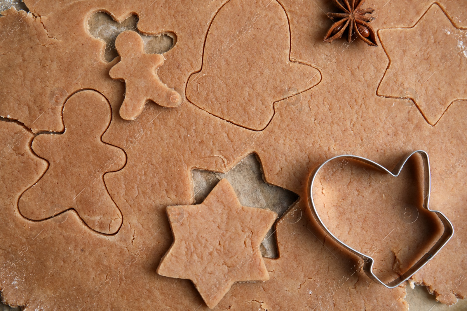 Photo of Making Christmas cookies. Raw dough and mitten shaped cutter on table, top view