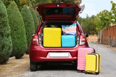 Photo of Car trunk fully loaded with suitcases outdoors