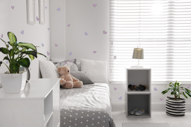 Image of Modern child room interior with comfortable bed near window 