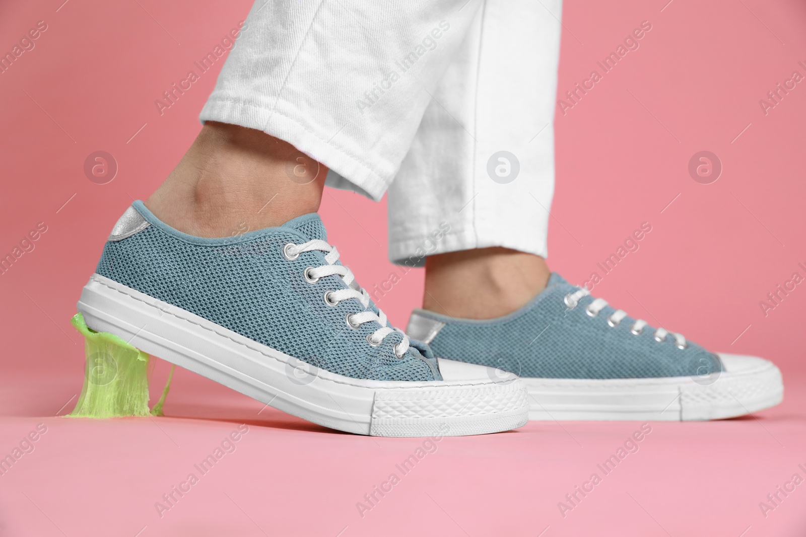 Photo of Person stepping into chewing gum on pink background, closeup