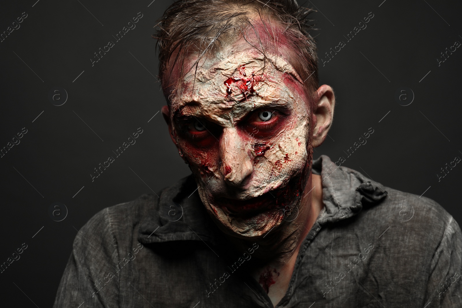 Photo of Scary zombie on dark background. Halloween monster