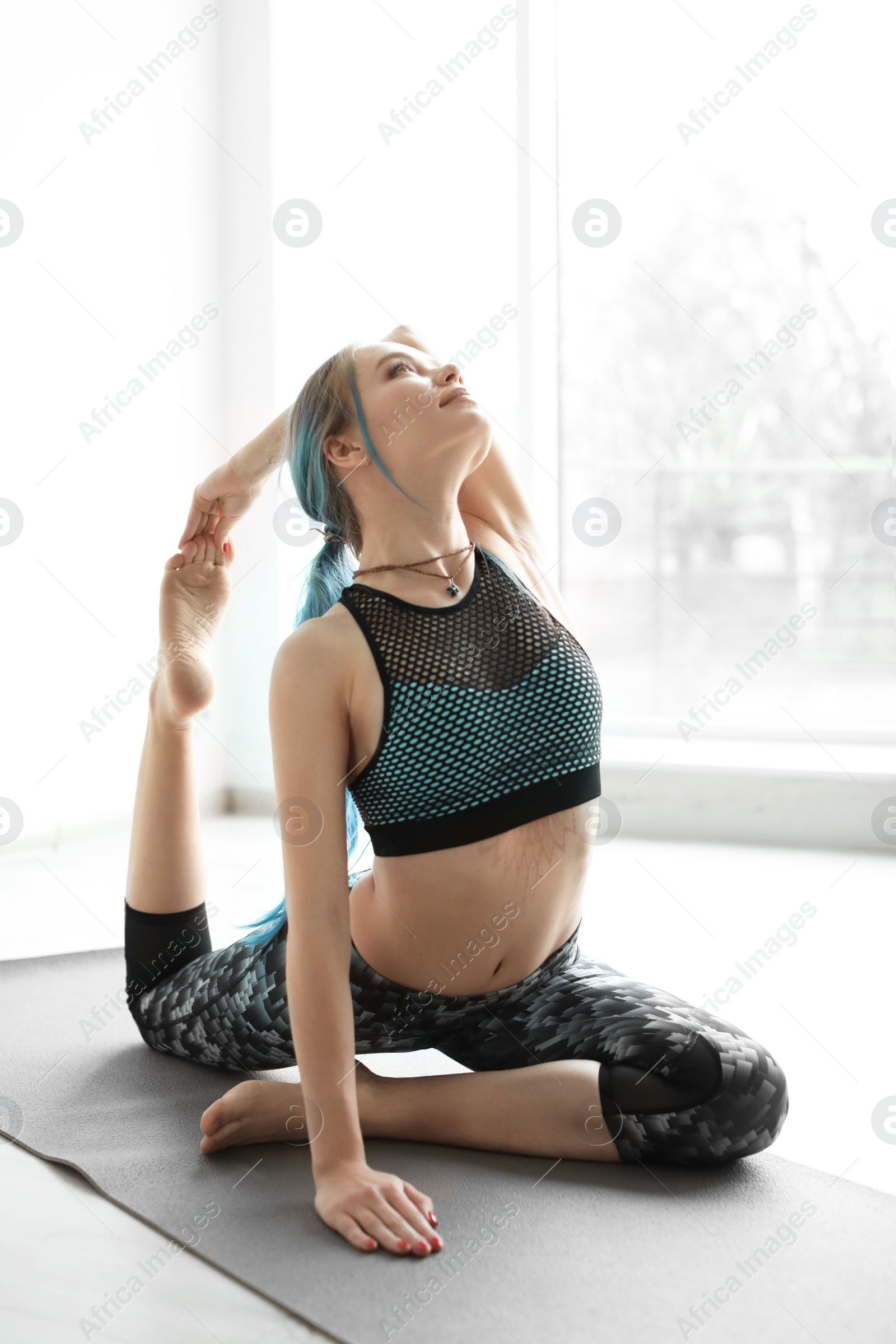 Photo of Young woman practicing yoga indoors