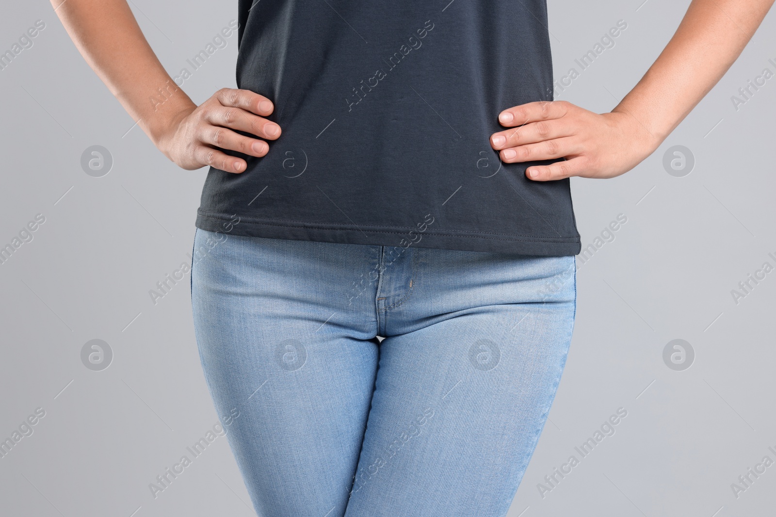 Photo of Woman wearing stylish jeans on light gray background, closeup
