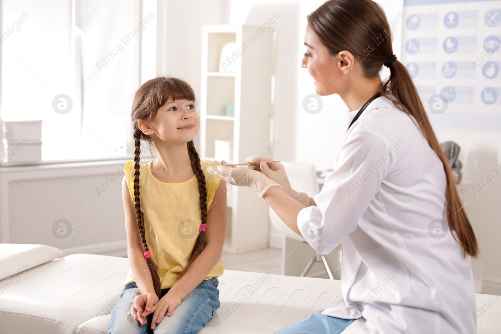 Photo of Doctor examining adorable child in hospital office